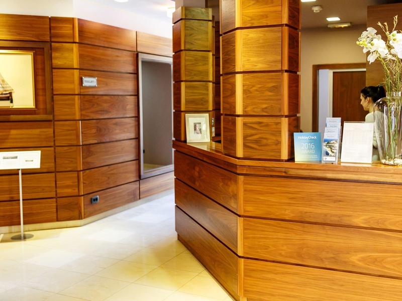 Réception d'hôtel élégante avec boiseries et éclairage moderne.