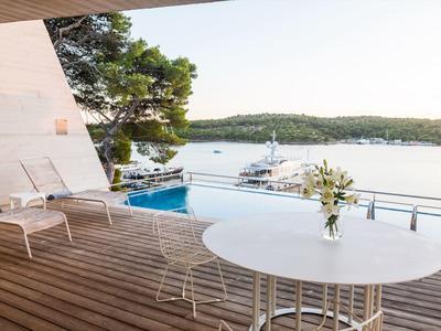 Terrazza con piscina e lettini vista mare e yacht.