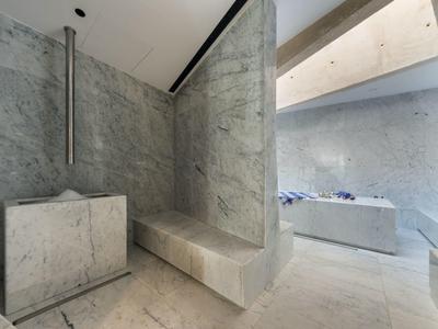 Espace bien-être moderne avec surfaces en marbre gris et design minimaliste dans l'hôtel.