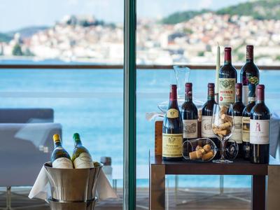 View of harbor and town from hotel terrace with wine bottles and ice bucket.