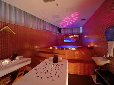 Pokój relaksacyjny z dwoma łóżkami do zabiegów i kojącym ciepłym światłem