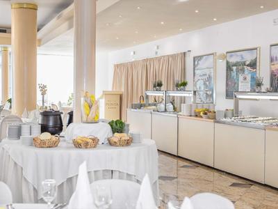 Eleganter Frühstücksraum mit gedeckten Tischen und Buffetbereich in hellem Ambiente.