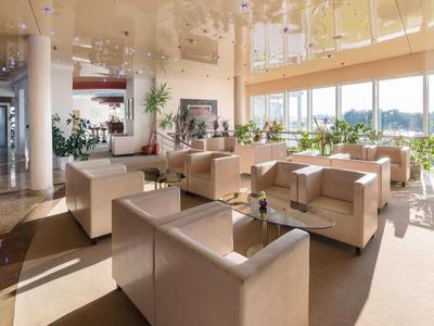 Jasny salon z wygodnymi fotelami i dużymi oknami wpuszczającymi dużo światła dziennego.