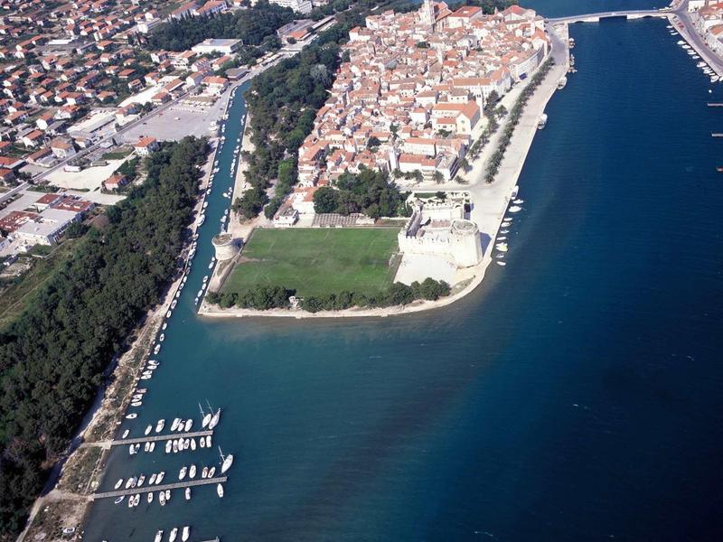 Zdjęcie z lotu ptaka miasta portowego z drogami wodnymi, łodziami i historycznymi budynkami nad morzem.