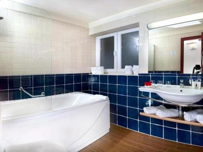 Moderne badkamer met bad, wastafel en blauw-witte tegels.