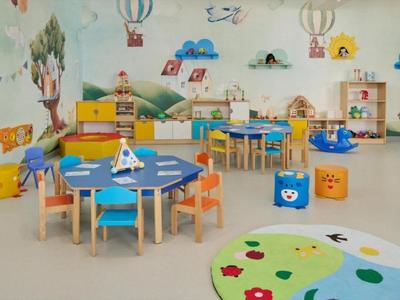 Kleurrijke kleuterklas met kindertafels, stoelen en muurschilderingen