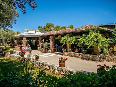 Een uitnodigend gebouw met natuursteen en planten in een zonnige tuin.