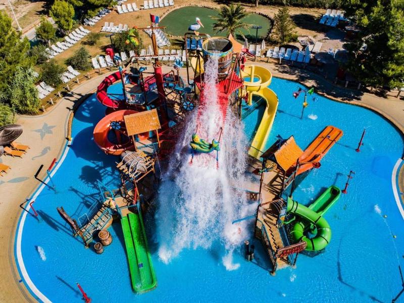 Levendig waterpark met kleurrijke glijbanen en spuitende fonteinen.