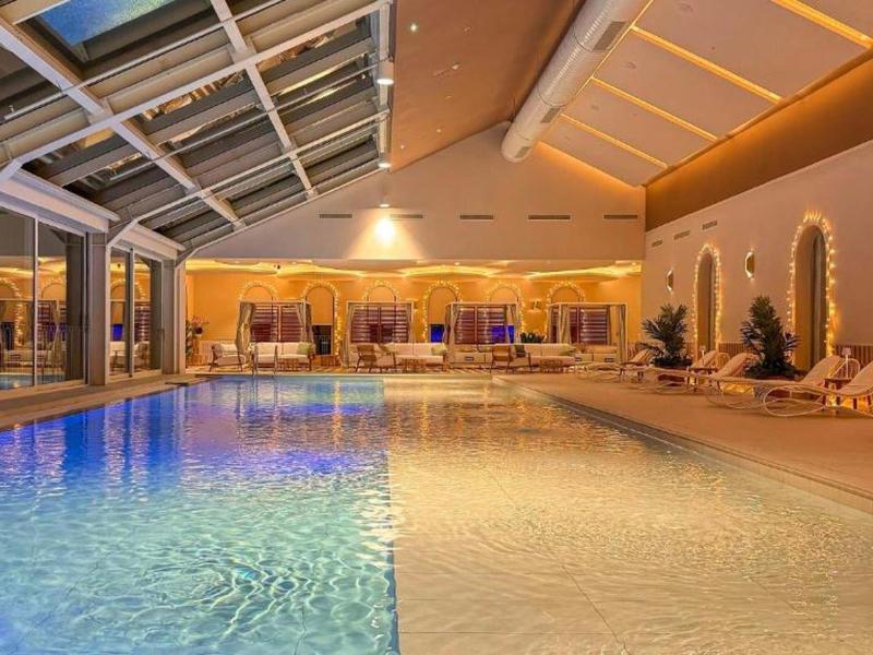 Binnenzwembad in een hotel met moderne verlichting en gezellige sfeer.