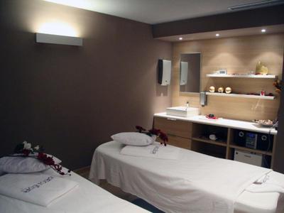 Rustige spa kamer met twee massagetafels en zachte verlichting.