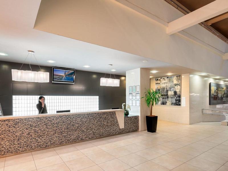 Lichte hotellobby met moderne receptiebalie en vriendelijk personeel.