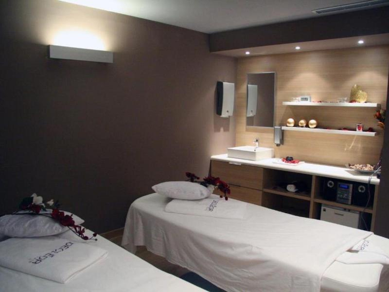 Rustige spa kamer met twee massagetafels en zachte verlichting.
