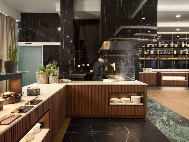 Moderne hotel lobby met serveerstation, zwarte muur en houten planken.