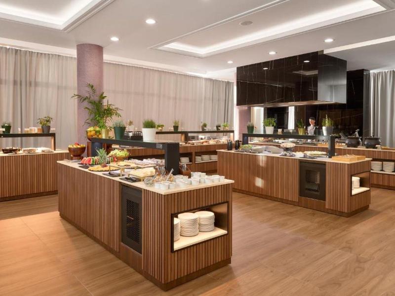 Ruime ontbijtruimte met buffeteilanden, houtdetails en modern design.