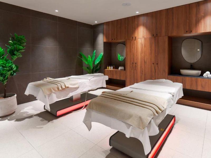 Gezellige spa-ruimte met twee massagetafels, warme houten accenten en een ontspannende sfeer.