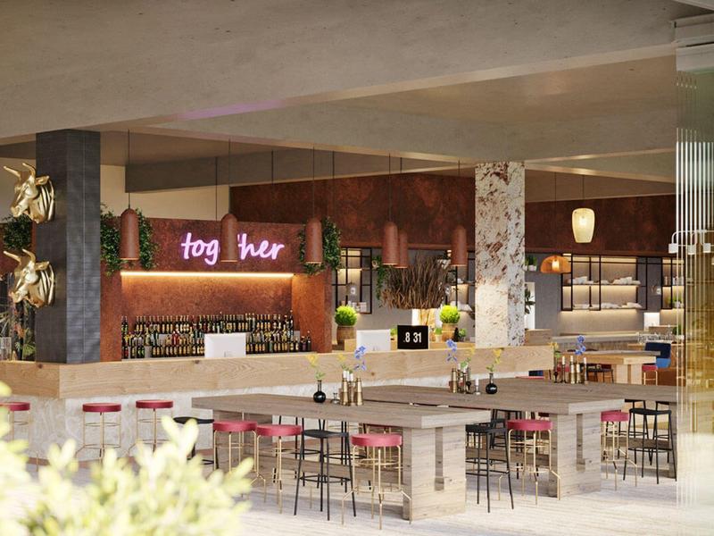 Modernes Café mit Theke, Holzstühlen und Neon-Schriftzug "fog her" an der Wand.