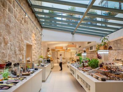 Espace buffet lumineux avec murs en pierre et toit en verre dans un restaurant d'hôtel.