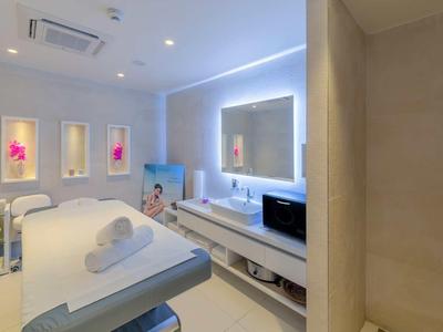 Salle de spa lumineuse et moderne avec lits de soins et éclairage apaisant.