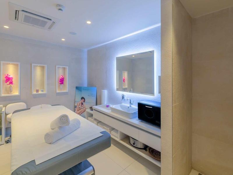 Salle de spa lumineuse et moderne avec lits de soins et éclairage apaisant.