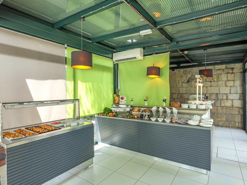 Strefa bufetu z oświetlonymi lampami i różnorodnymi potrawami w nowoczesnym otoczeniu.