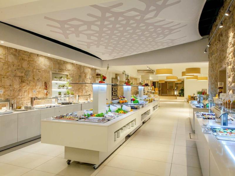 Modern buffet met diverse gerechten in een elegant, helder restaurant.