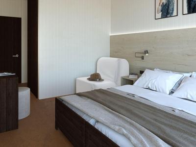 Camera d'hotel moderna con letto matrimoniale, poltrona e decorazione semplice in tonalità neutre.