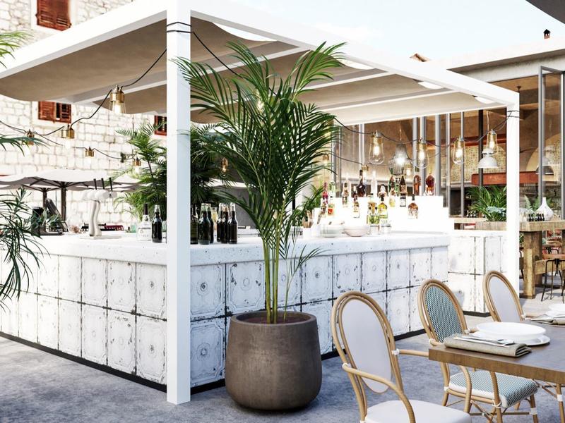 Helder modern terras van een café met witte tafels en grote potplanten.
