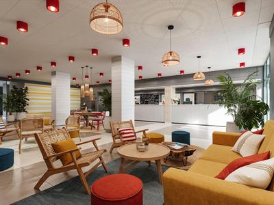 Moderne Hotellobby mit gemütlichen Sitzbereichen, bunten Möbeln und einer Rezeption im Hintergrund.