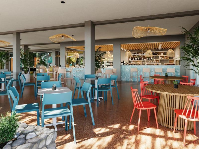 Modernes Café mit blauen und roten Stühlen, Holztischen und viel natürlichem Licht.