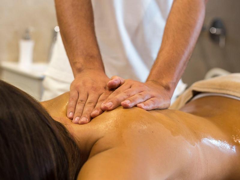 Person erhält entspannende Rückenmassage in Hotel-Spa mit warmem Öl