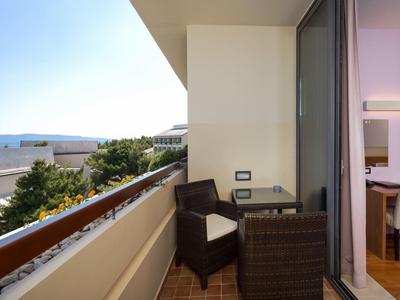 Balcone con mobili da esterno e vista sul mare adiacente a una sala da pranzo moderna