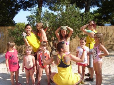 Bambini e assistenti in abbigliamento estivo all'aperto con tempo soleggiato.