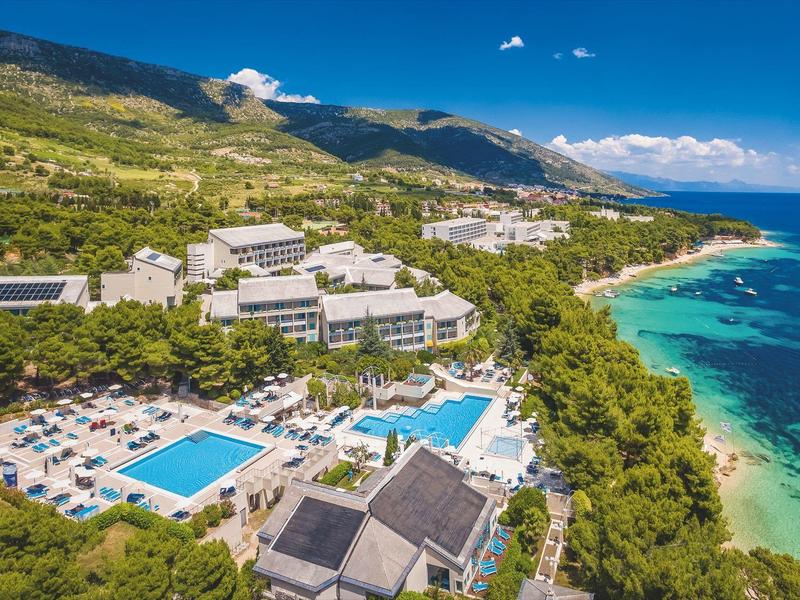 Complesso alberghiero sulla costa con più piscine e vista sul mare turchese.