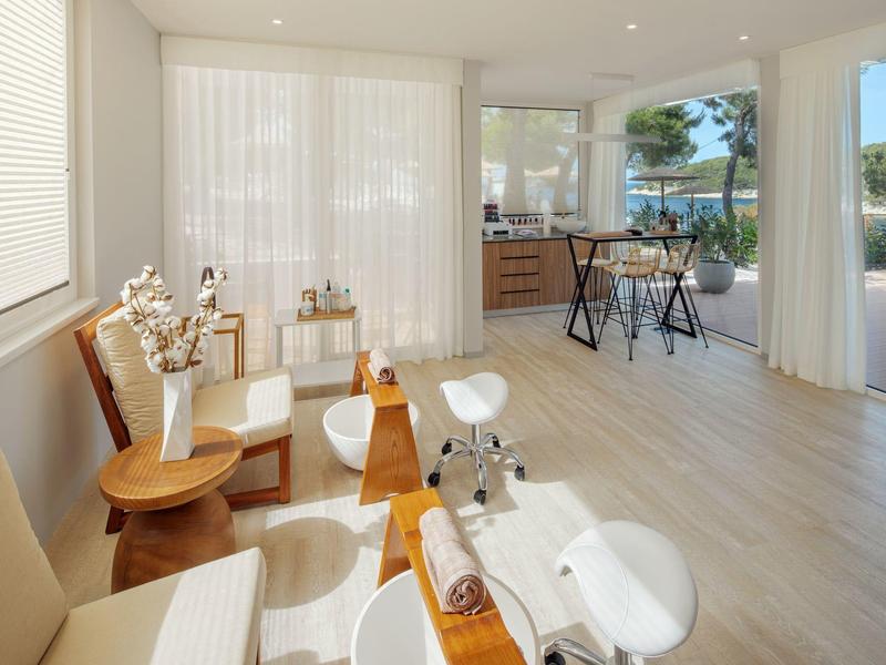 Světlá, moderní spa s pohodlnými křesly a velkými okny s výhledem na stromy.