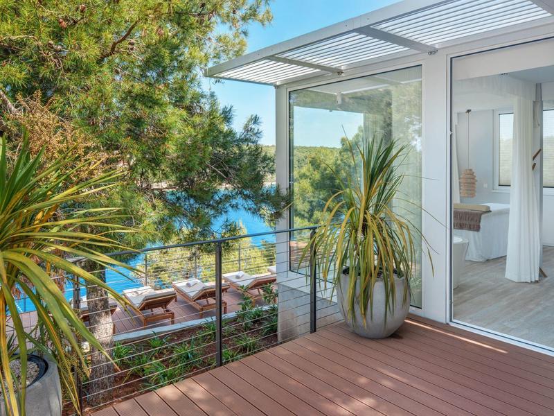 Terrazza con piante, vista sul mare e salotto esterno moderno.