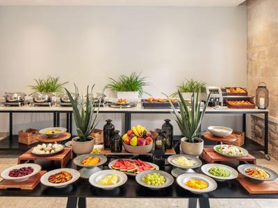 Buffet mit frischem Obst, Gemüse und Backwaren, dekoriert mit Pflanzen und Laternen.