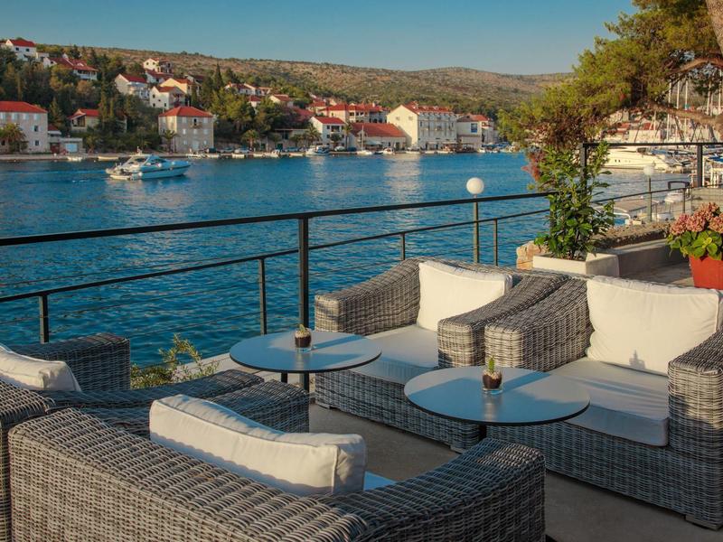 Gemütliche Sitzgruppe mit Blick auf Wasser und Häuser am Ufer.