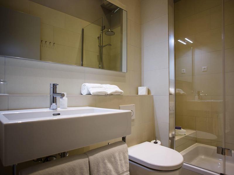 Moderne badkamer met wastafel, toilet en inloopdouche met glazen wand.