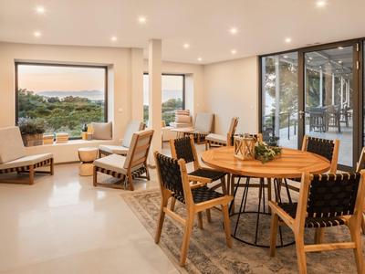 Salle à manger et salon lumineux avec meubles en bois et grande fenêtre avec vue.
