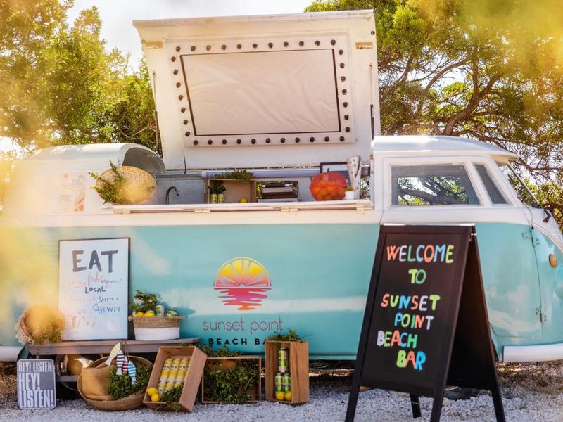 Camion-restaurant coloré par une journée ensoleillée avec menu et panneau de bienvenue.