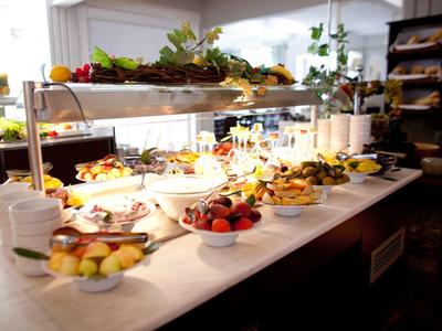 Buffet con vari piatti e frutta in una stanza luminosa e accogliente.