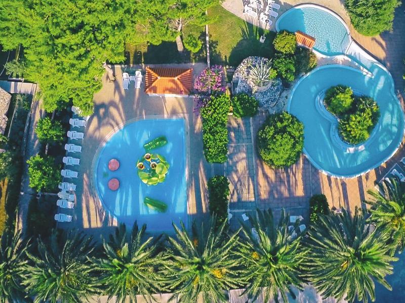 Vista aerea di un parco acquatico con più piscine e molta vegetazione