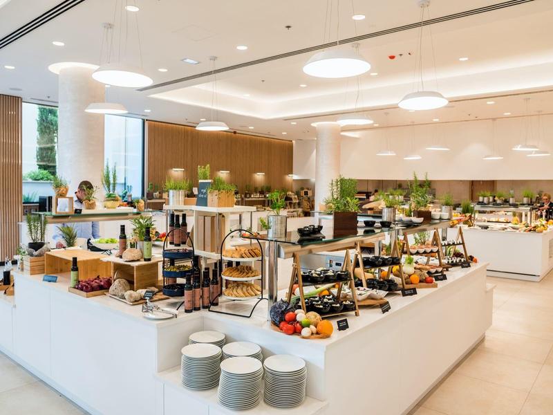 Modernes, helles Buffet mit vielfältigem Frühstücksangebot in elegantem, offenem Raum.