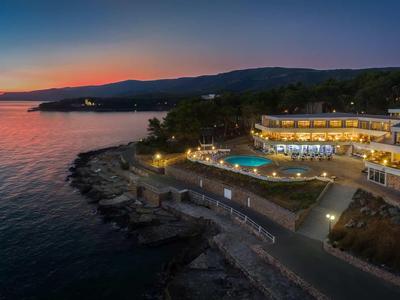 Luxuriöses Hotel mit Pool am Meer bei Sonnenuntergang auf einer Klippe