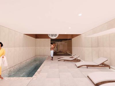 Zona de piscina cubierta moderna con tumbonas y ambiente relajante