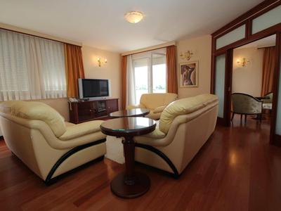 Cozy living room with beige sofas, wooden floor, and window with curtains.