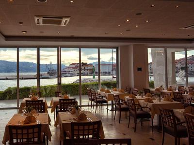 Een stijlvol restaurant met uitzicht op een meer en bergen bij zonsondergang.