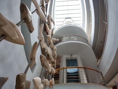 Moderne hotel lobby met sculpturale wandkunst en ronde dakraam.