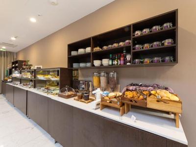 Langer Frühstücksbuffet mit Gebäck, Müsli und Getränken in modernem Hotel.