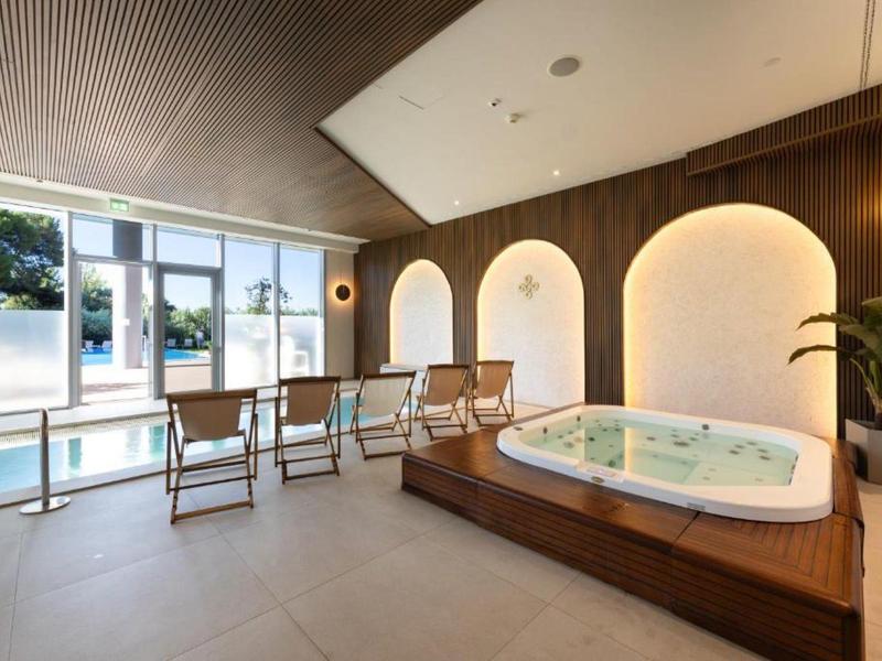 Moderner Wellnessbereich mit Whirlpool und Pool in natürlichem Licht.